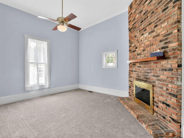 unfurnished living room featuring ceiling fan, carpet floors, a healthy amount of sunlight, and a brick fireplace