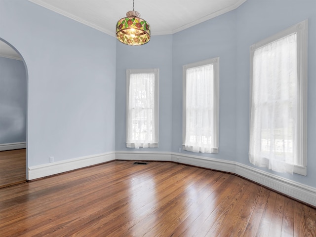 empty room with wood-type flooring and ornamental molding