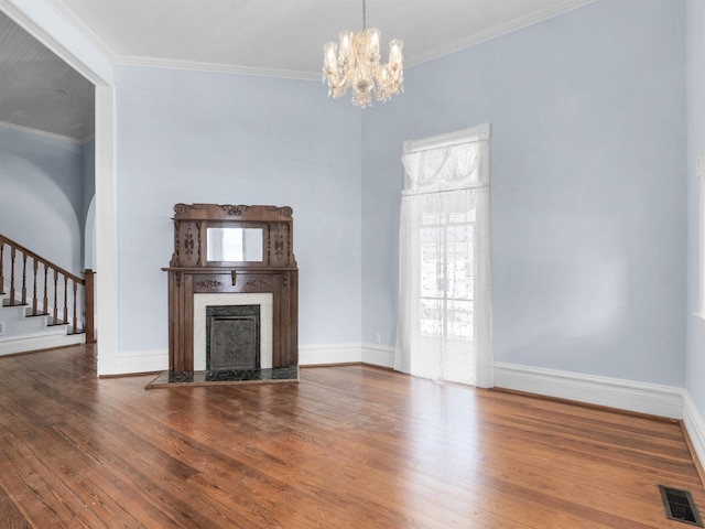 unfurnished living room featuring crown molding, hardwood / wood-style floors, and an inviting chandelier