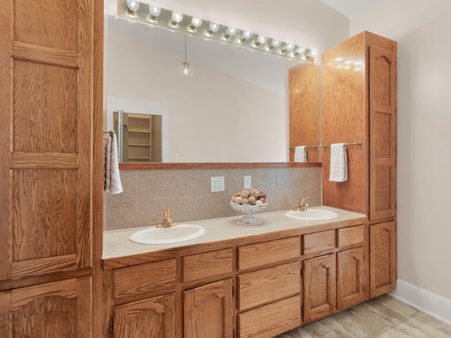 bathroom featuring hardwood / wood-style flooring, vanity, and tasteful backsplash