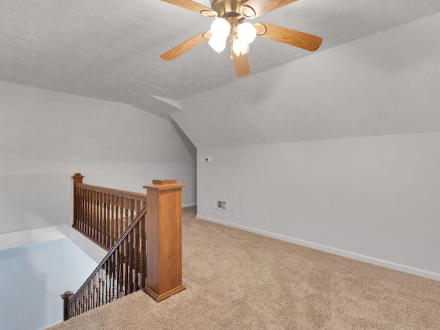 bonus room with light carpet, a textured ceiling, ceiling fan, and lofted ceiling