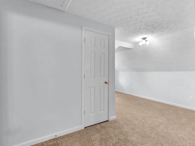 bonus room with a textured ceiling, lofted ceiling, and carpet floors