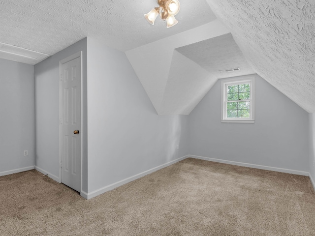 bonus room featuring lofted ceiling, carpet, and a textured ceiling