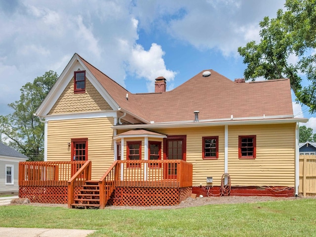 back of property featuring a yard and a wooden deck