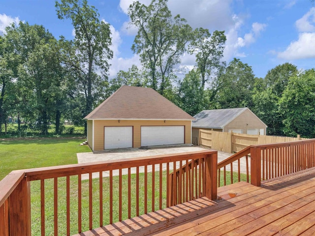 wooden terrace with a lawn, a garage, and an outbuilding