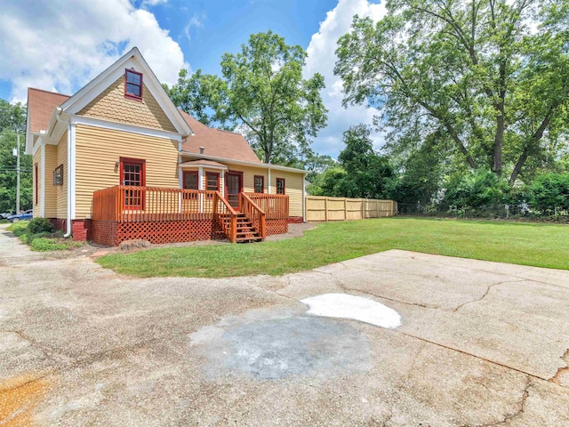 rear view of house with a lawn and a wooden deck