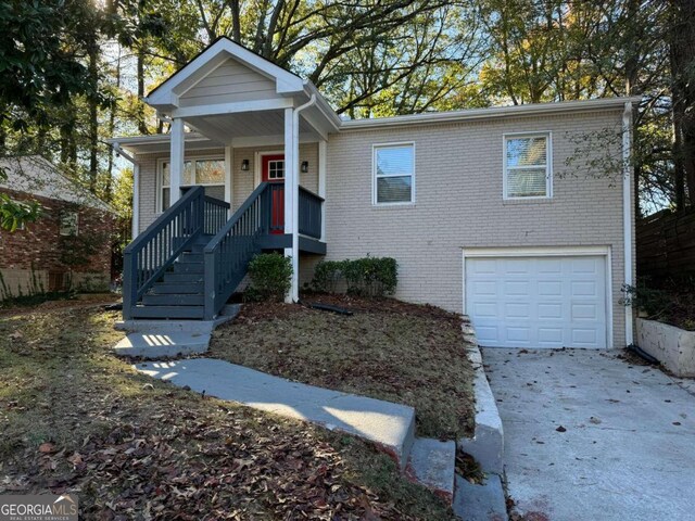 3152 Delmar Ln NW, Atlanta, GA 30311 - view of front of property with a garage, driveway, brick siding, and covered porch