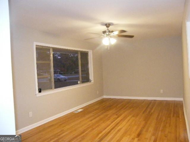 unfurnished room with hardwood / wood-style floors and ceiling fan