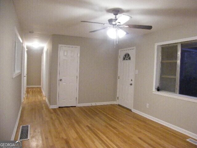 empty room with light hardwood / wood-style floors and ceiling fan