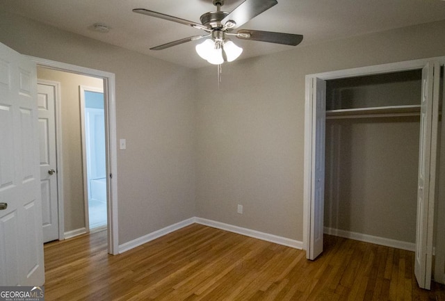 unfurnished bedroom featuring hardwood / wood-style flooring, ceiling fan, and a closet