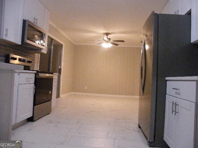 kitchen featuring appliances with stainless steel finishes, white cabinets, ceiling fan, and decorative backsplash