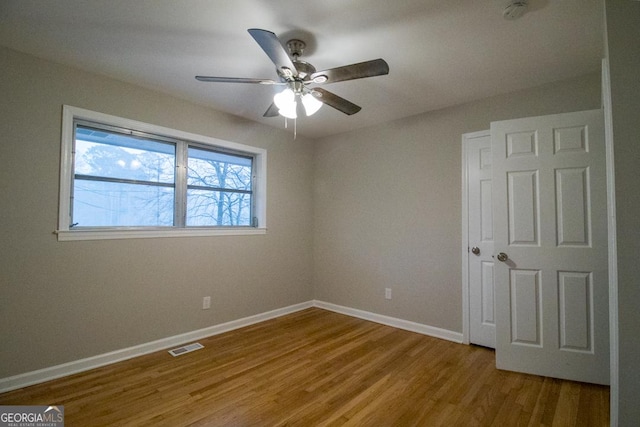 empty room with hardwood / wood-style flooring and ceiling fan