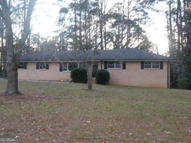 single story home featuring a front lawn