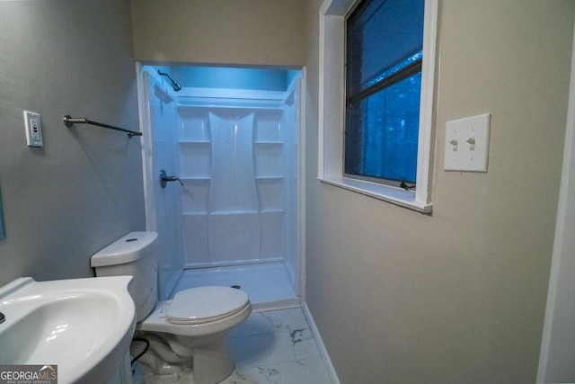 bathroom featuring toilet, sink, and a shower