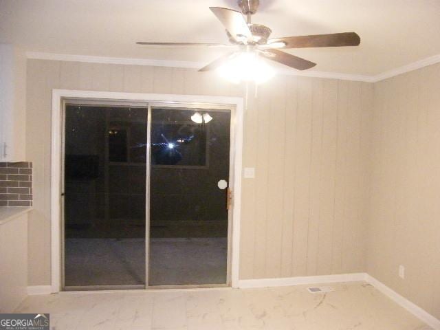 interior space with crown molding, ceiling fan, and wooden walls