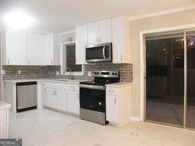 kitchen with white cabinetry, sink, backsplash, and appliances with stainless steel finishes