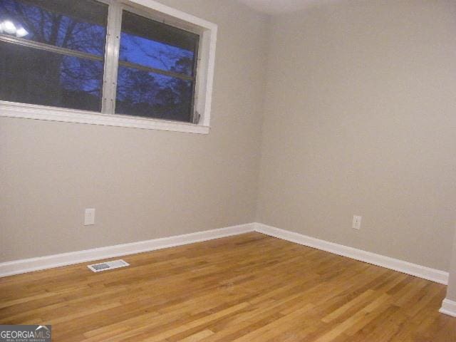 unfurnished room with wood-type flooring