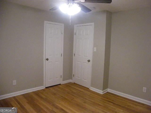 empty room with hardwood / wood-style floors and ceiling fan