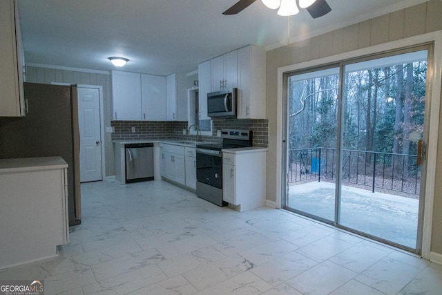 kitchen with white cabinetry, ornamental molding, appliances with stainless steel finishes, and sink