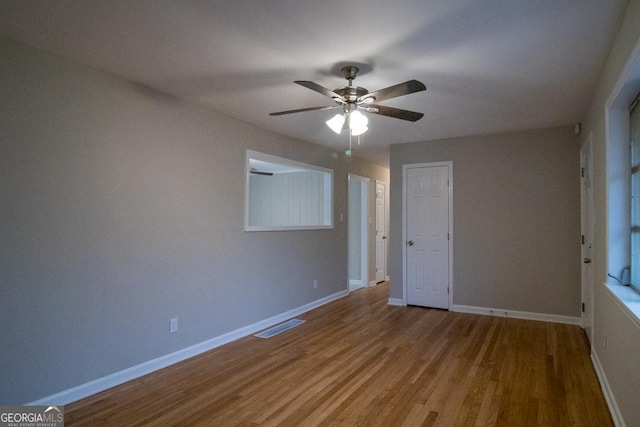 unfurnished bedroom with hardwood / wood-style flooring, ceiling fan, and a closet