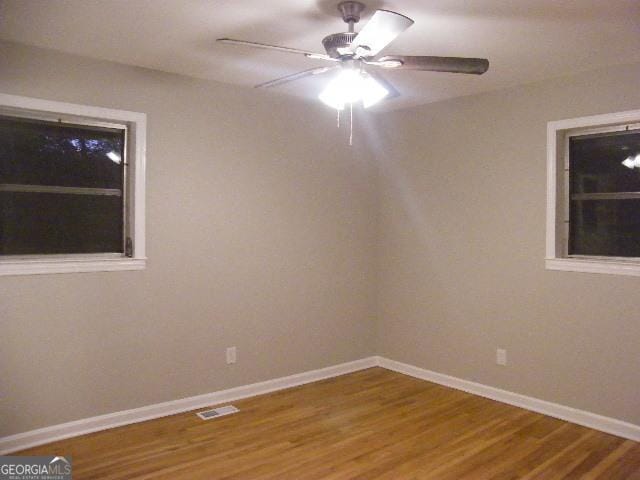 spare room featuring wood-type flooring and ceiling fan