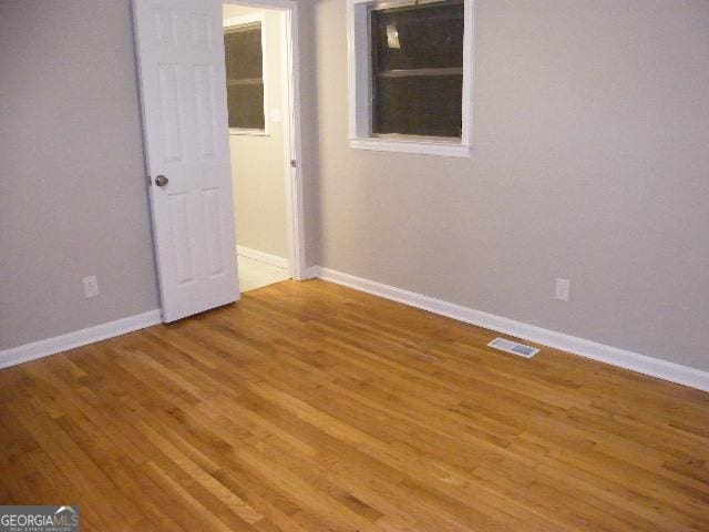 spare room featuring wood-type flooring