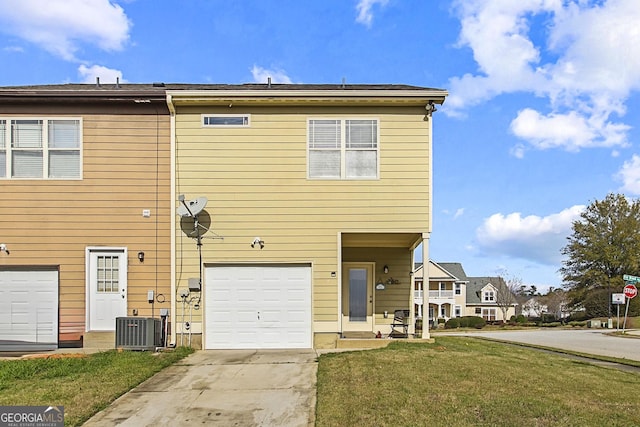 view of front of property featuring central air condition unit, a front yard, and a garage