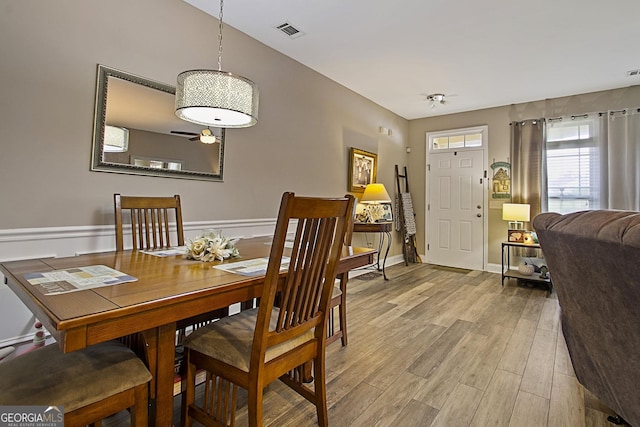 dining area with light wood-type flooring and ceiling fan