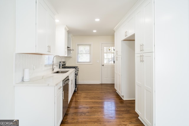 kitchen featuring dark wood-type flooring, sink, light stone countertops, white cabinetry, and stainless steel appliances