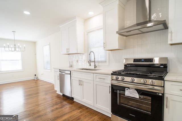 kitchen with sink, wall chimney exhaust hood, plenty of natural light, and appliances with stainless steel finishes