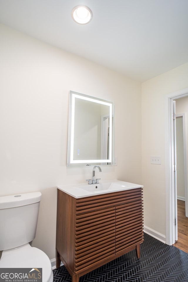 bathroom with hardwood / wood-style floors, vanity, and toilet