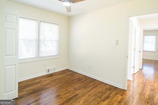 spare room featuring dark hardwood / wood-style flooring and a healthy amount of sunlight