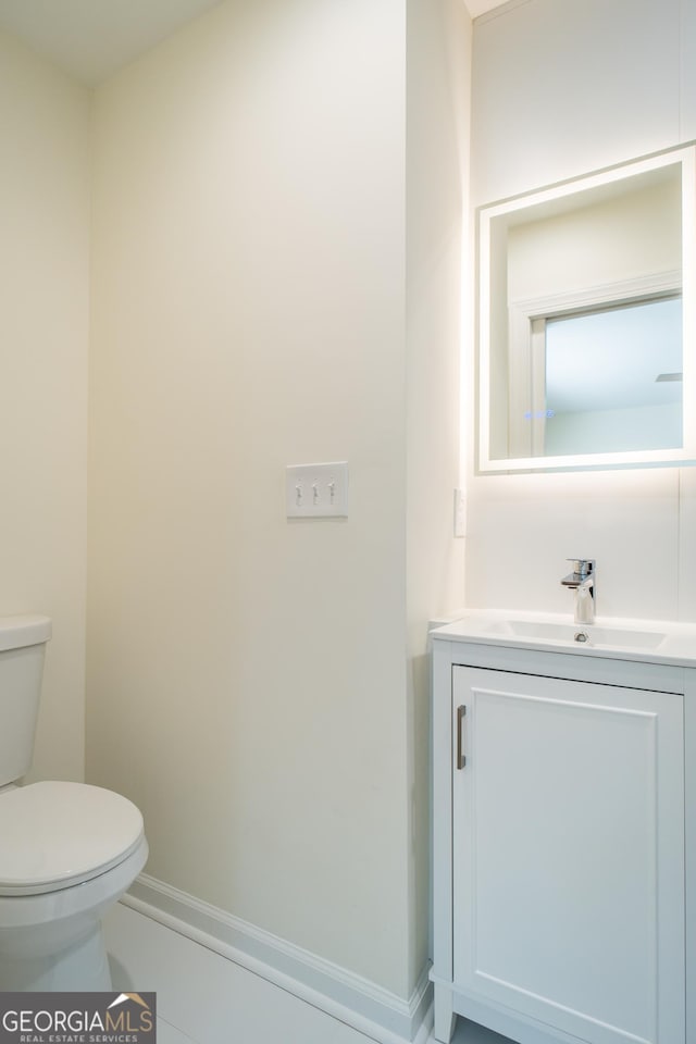 bathroom with tile patterned flooring, vanity, and toilet