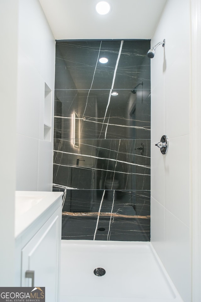 bathroom featuring vanity and a tile shower