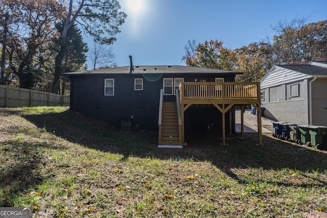 rear view of house with a yard, central AC, and a wooden deck