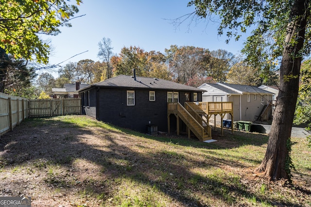 rear view of house featuring a yard, cooling unit, and a deck