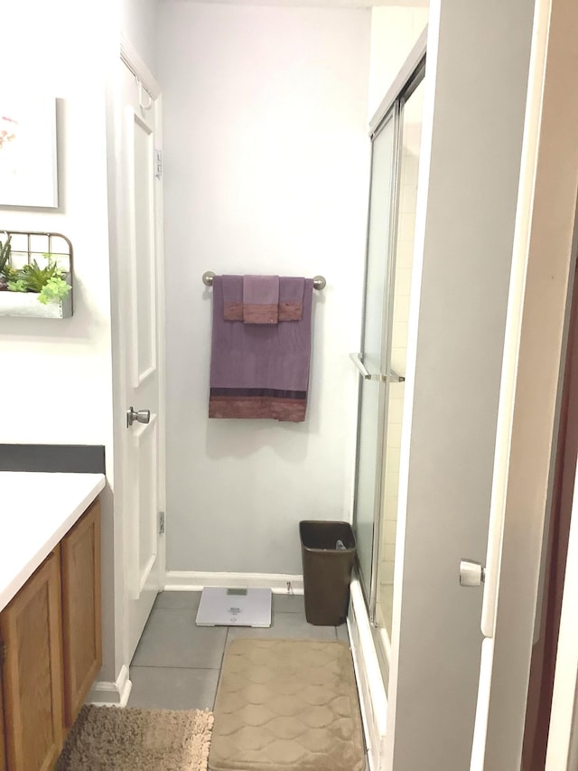 bathroom featuring tile patterned flooring, vanity, and a shower with shower door