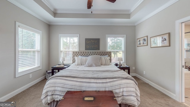 bedroom with light colored carpet, ceiling fan, crown molding, and a tray ceiling