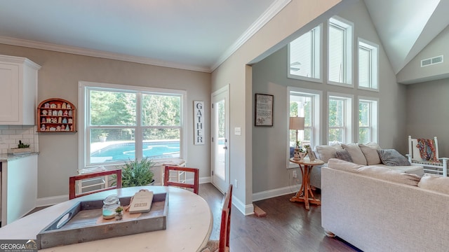 dining area featuring dark hardwood / wood-style floors, ornamental molding, and lofted ceiling