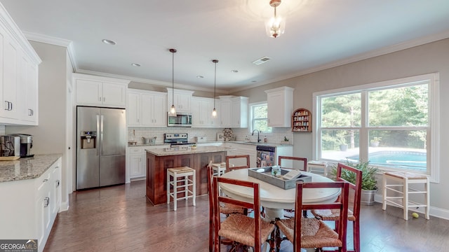 dining area featuring crown molding, sink, and dark wood-type flooring