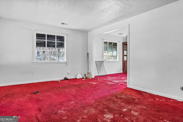 carpeted spare room with a textured ceiling