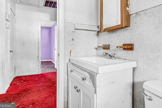 kitchen featuring white cabinets, tile walls, and sink