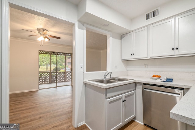 kitchen with sink, ornamental molding, stainless steel dishwasher, and light wood-type flooring