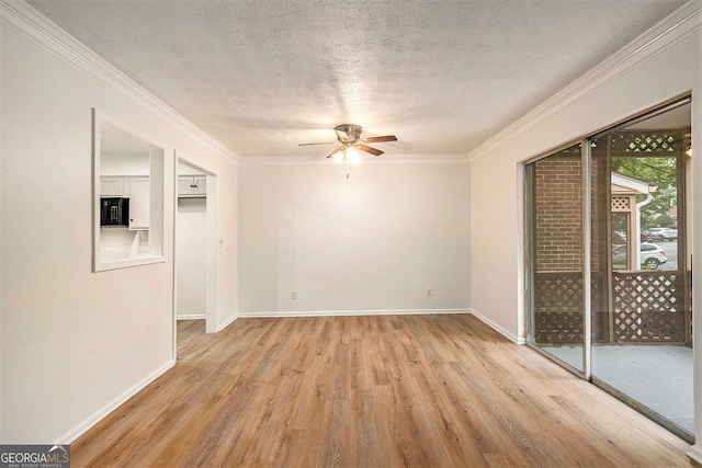 spare room with ceiling fan, ornamental molding, a textured ceiling, and light wood-type flooring