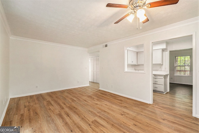 unfurnished living room with crown molding, ceiling fan, a textured ceiling, and light wood-type flooring