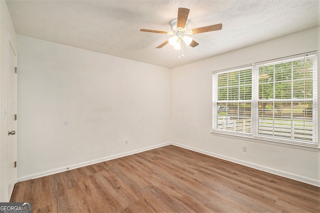 empty room featuring ceiling fan, hardwood / wood-style floors, and a textured ceiling