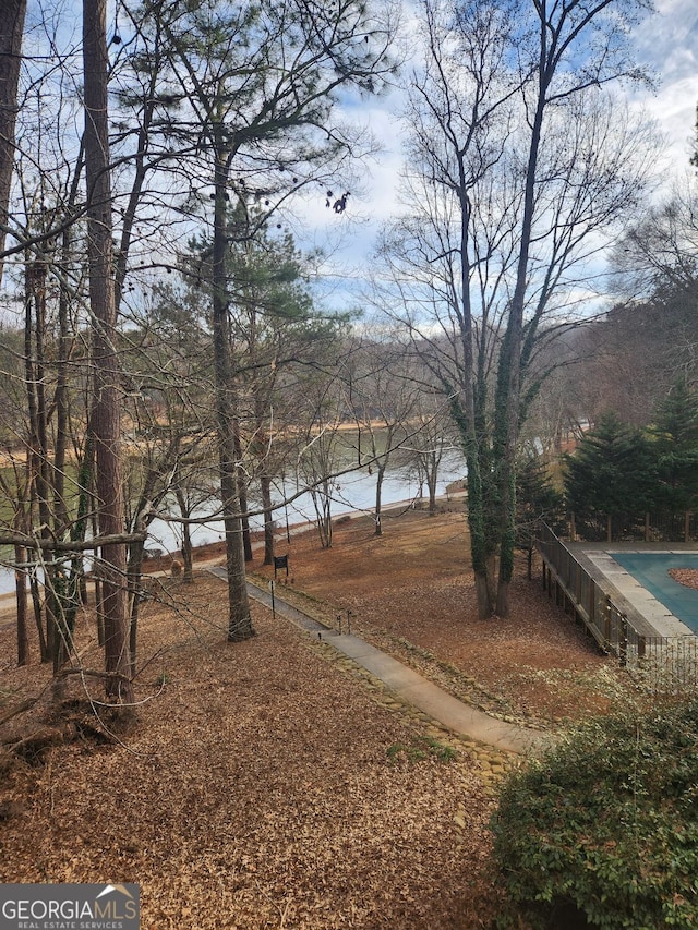 view of yard featuring a water view and a covered pool