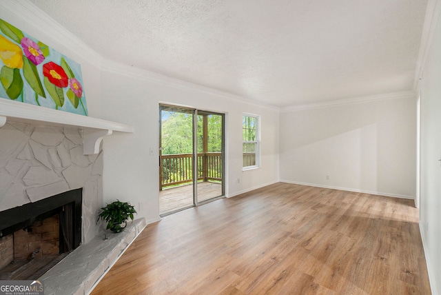 unfurnished living room with light hardwood / wood-style flooring, a fireplace, ornamental molding, and a textured ceiling