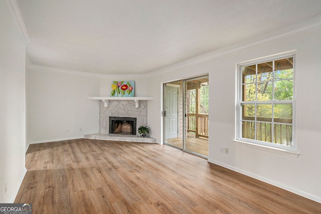 unfurnished living room with ornamental molding, a fireplace, and light hardwood / wood-style flooring