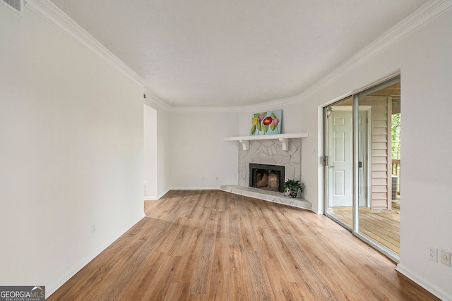 unfurnished living room with crown molding, a fireplace, and light hardwood / wood-style floors